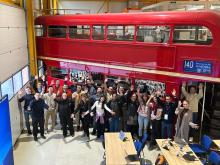 A group picture in front of a big red bus